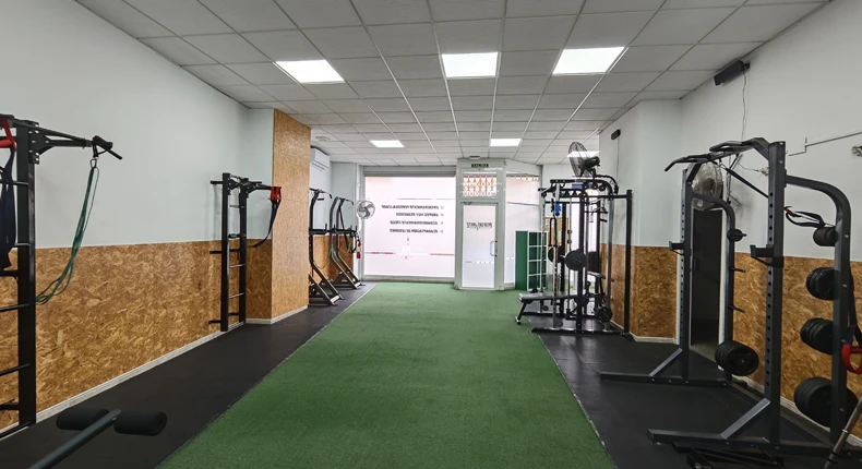 Vista general del gimnasio Performante con césped artificial central y máquinas de fuerza a ambos lados
